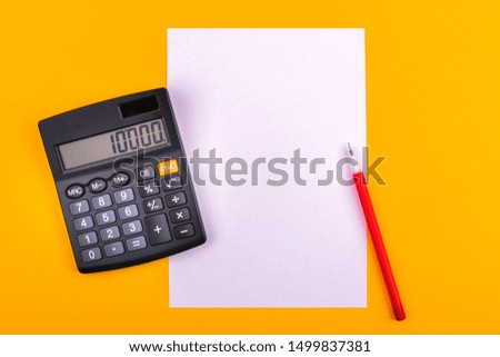 Black calculator and red pen on a white sheet of paper for notes, counts and notes, lie on an orange background