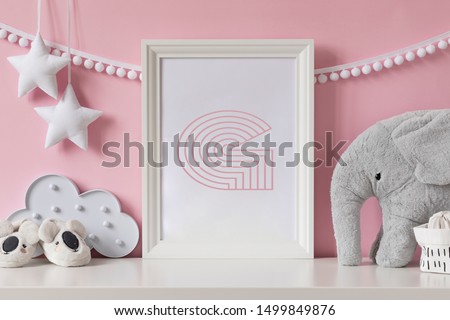 Modern scandinavian newborn baby room with mock up poster frame, plush elephant, cloud, shoes and children accessories. Cozy interior with pink walls. Haniging cotton garland and stars. Template.