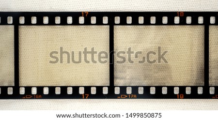long vintage 35mm film strip on linen material background with empty or blank frames