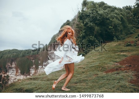 A beautiful girl in a vest and white dress, runs to the ocean,beautiful curly blond hair develops in the wind and she is happy,tenderness, sun,waves, pleasure and happiness, tan, skin, crazy Bali,boho