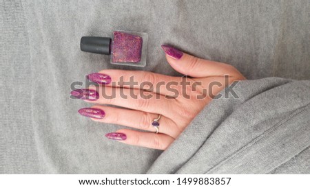 Female hands with long nails with purple fuchsia nail polish