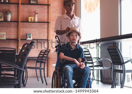 Father helping disabled child on the wheelchair,Dad teach and help enhance the skills needed in daily life,Special children's lifestyle, Life in the education age of kids,Happy disability kid concept.
