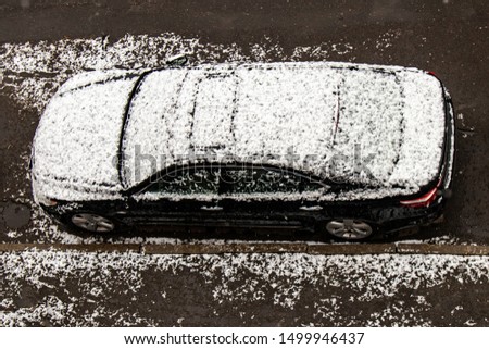 Brown Car covered with snow in the winter blizzard.Extreme snowfall