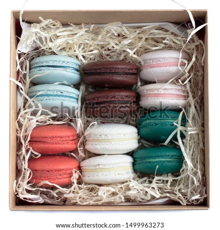 Top view on a gift box of colorful French macaroons isolated on white background. Close-up.