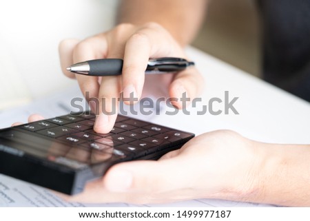 Man using calculator and calculate bills receipt in home expenses payments costs with paper note, financial account management and payment or saving concept
