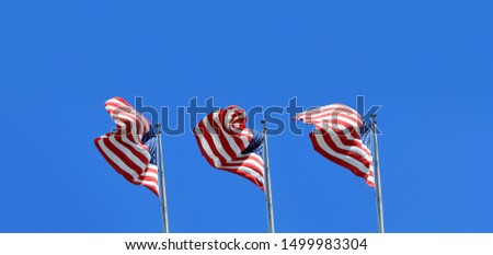 Conceptual image of waving American flags hanged at tall pole in a row over clear blue sky
