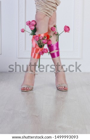 Perfect female long legs in high heels with flowers.