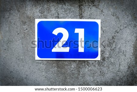21, number twenty-one, blue number plate on graded gray background.