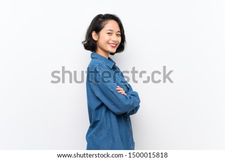 Asian young woman over isolated white background with arms crossed and looking forward