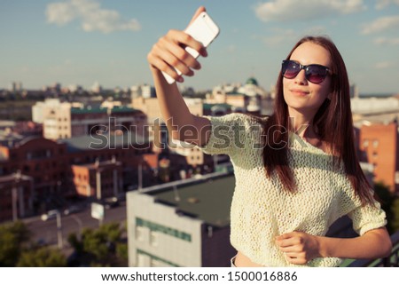 Young woman tourist taking selfie. Urban background.