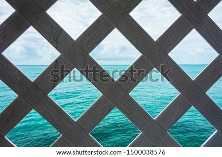 Wooden grill with the Bahamian sea in the background.