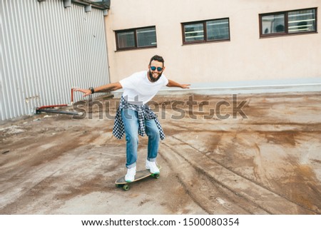 A young hipster rides longboard outdoor