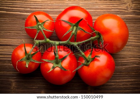 Tomato bunch on a wooden background.