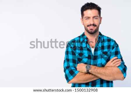 Portrait of happy young bearded hipster man smiling with arms crossed