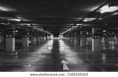 Underground car parking lot. Underground car parking garage at shopping mall or international airport. Indoor parking area. Concrete basement floor parking garage. Interior building in the city.