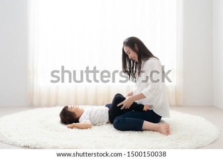 portrait of young asian mother and baby in living room