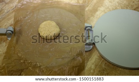 Keto tortilla dough on a tortilla press.