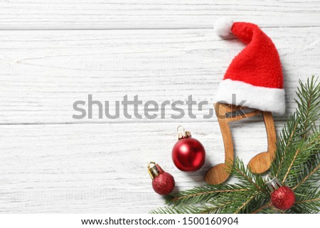 Flat lay composition with note on white wooden background, space for text. Christmas music concept