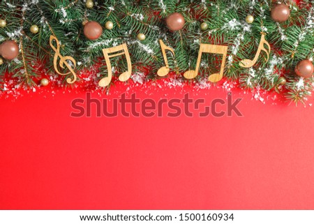Flat lay composition with Christmas decor and music notes on red background, space for text