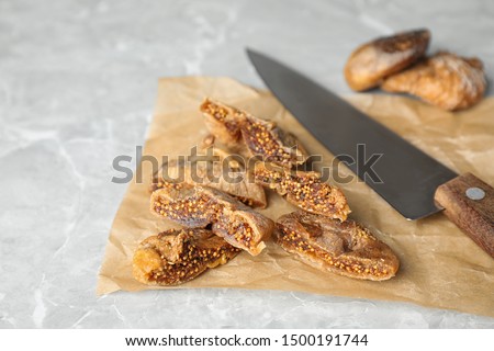Tasty cut dried figs on light grey marble table, closeup