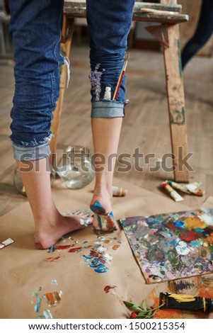 Legs only. Young creative woman is in art studio. Conception of painting.