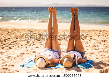 Young girls with legs up on the beach
