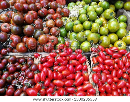 Various kinds of tomatoes on wooden boxes in the farmer market 