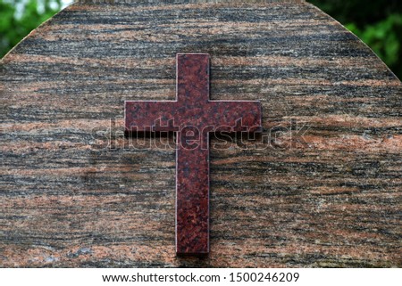 Closeup of Stone cross on graves in cemetery.