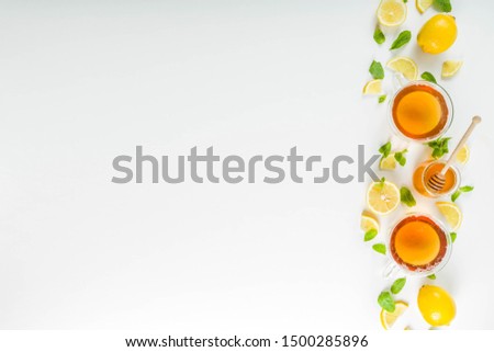Autumn tea with mint and lemon with ingredients - fresh mint leaves, sliced lemon and honey, white background copy space