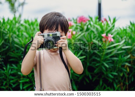 little boy fun and enjoying learning professional photographer taking a picture using a vintage retro film, Educational and learning concept.