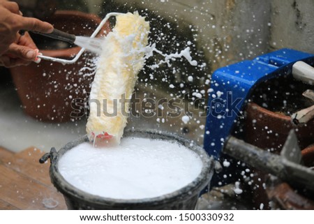 Cleaning paint roller after painting Royalty-Free Stock Photo #1500330932