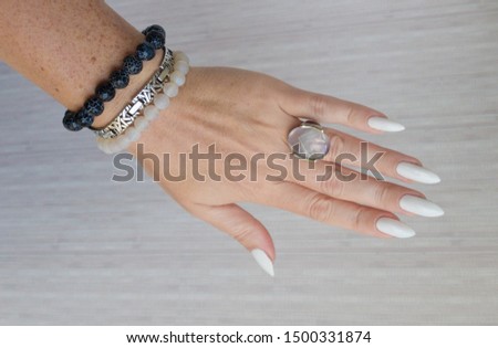 Female hands with long nails with white gray nail polish
