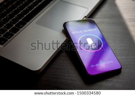 Voice search siri technology, sound recognition, speech detect and deep learning concept. Voice search application with microphone and wave icon on mobile phone screen. Royalty-Free Stock Photo #1500334580