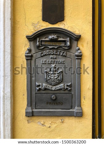 An old mailbox with vintage yellow walls in small alleys around Sirmione, Italy.