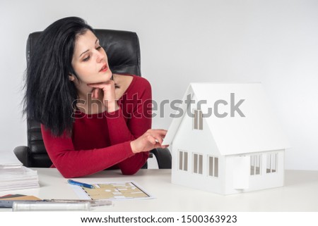 The girl works as an interior designer. Development of a design project of a new house using construction drawings and layout. Architect at work.