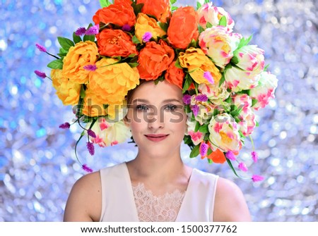 A large photo portrait of a girl with a floral wreath on her head on a bright background. Well-groomed hair, excellent facial skin.