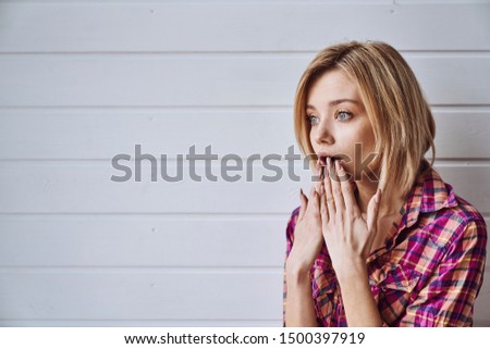 Portrait of young cheerful emotional beautiful blonde girl on light background