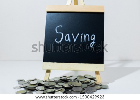 saving coin and a mini blackboard with text