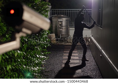 Thief use crowbar break into a house at window being caught by CCTV, surveillance camera Royalty-Free Stock Photo #1500443468