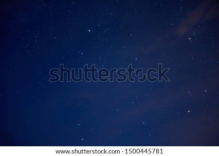 Starry sky with little clouds. Bright colored stars over us on the dark blue sky background.