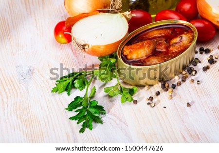 Picture of  tasty stuffed squid in tomato sauce on background with greens, tomatoes and onion