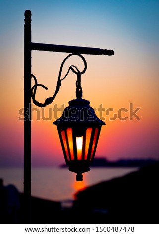 The magic light of the rising sun through the glass of a decorative lantern. Morning seascape