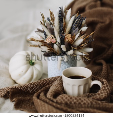 Coffee cup with flowers and pumpkins on a cozy plaid. Autumn still life. Breakfast in bed. Good morning. Stylish autumn flat lay. Hello fall. Cozy warm image
