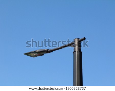 abstract perspective view of modern street light with square LED lamp head. blue sky in perspective view on pewter color tubular light pole. blue sky background. street lighting technology concept