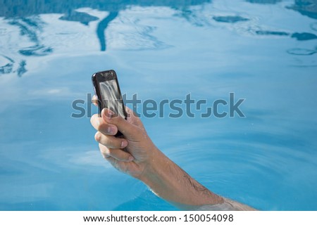 man bathing in a pool with your  smart phone mobile phone  without getting wet
