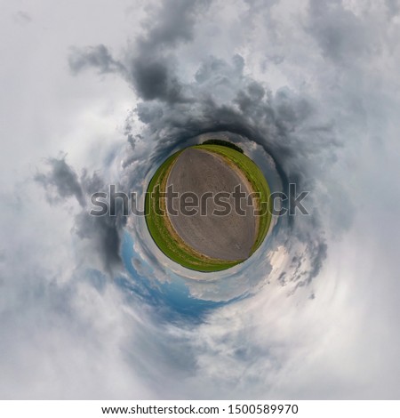 Little planet transformation of spherical panorama 360 degrees. Spherical abstract aerial view in field in nice evening with awesome beautiful clouds. Curvature of space.