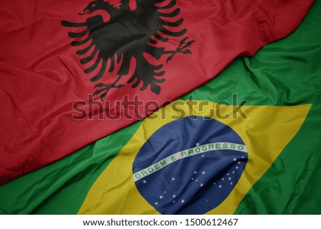 waving colorful flag of brazil and national flag of albania. macro