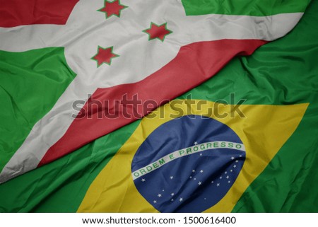 waving colorful flag of brazil and national flag of burundi . macro