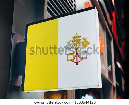 Flag of Holy See on Shop Sign. Flag of Holy See on Advertisement Board