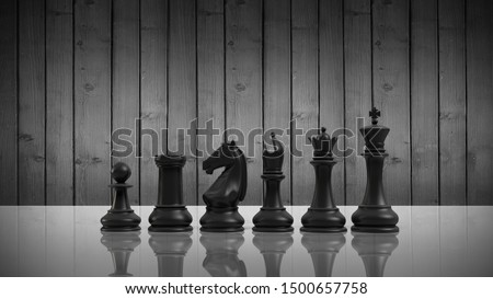 Black chess pieces on a white table on a wooden background